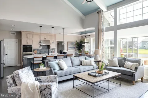 a living room with furniture kitchen view and a large window