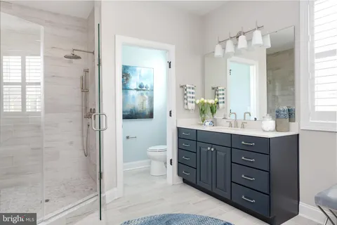 a bathroom with a double vanity sink toilet and shower