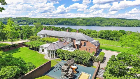 an aerial view of a house with outdoor space and lake view
