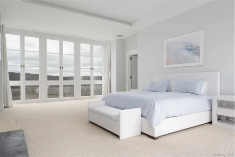 a spacious bedroom with a bed and a large window