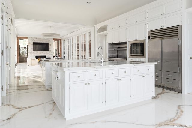 a large white kitchen with granite countertop a sink and dishwasher