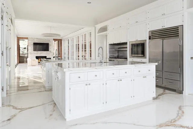 a large white kitchen with granite countertop a sink and dishwasher