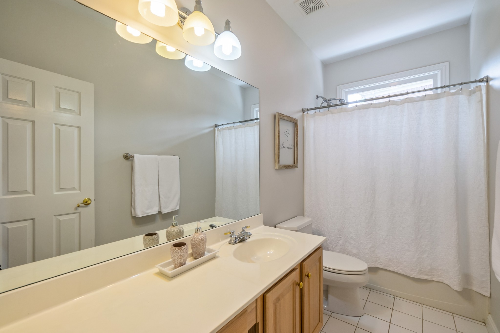 413 Doe Ridge Franklin, TN 37067 - Photo 26 of 42 a bathroom with a sink a toilet a mirror and shower curtain
