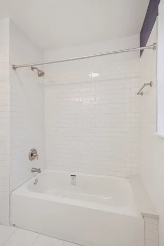 a bathroom with a shower and a bath tub