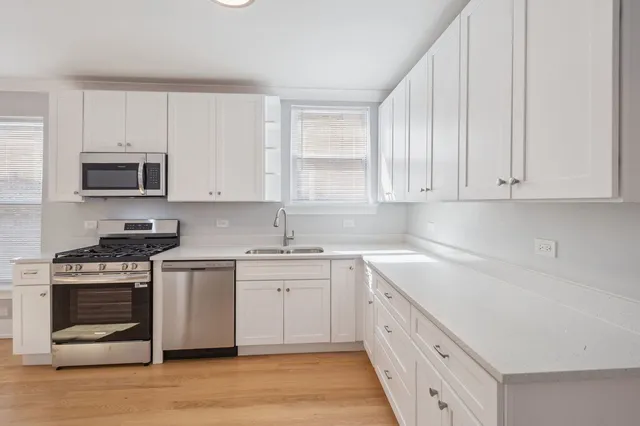 a kitchen with stainless steel appliances granite countertop a sink and a stove
