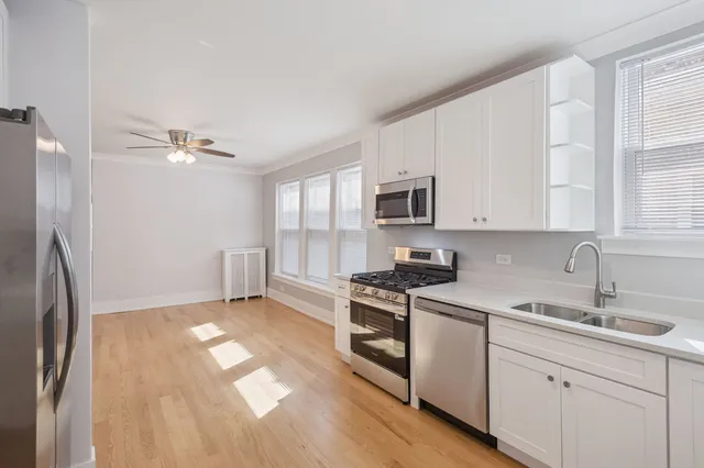 a kitchen with stainless steel appliances a sink cabinets and a window