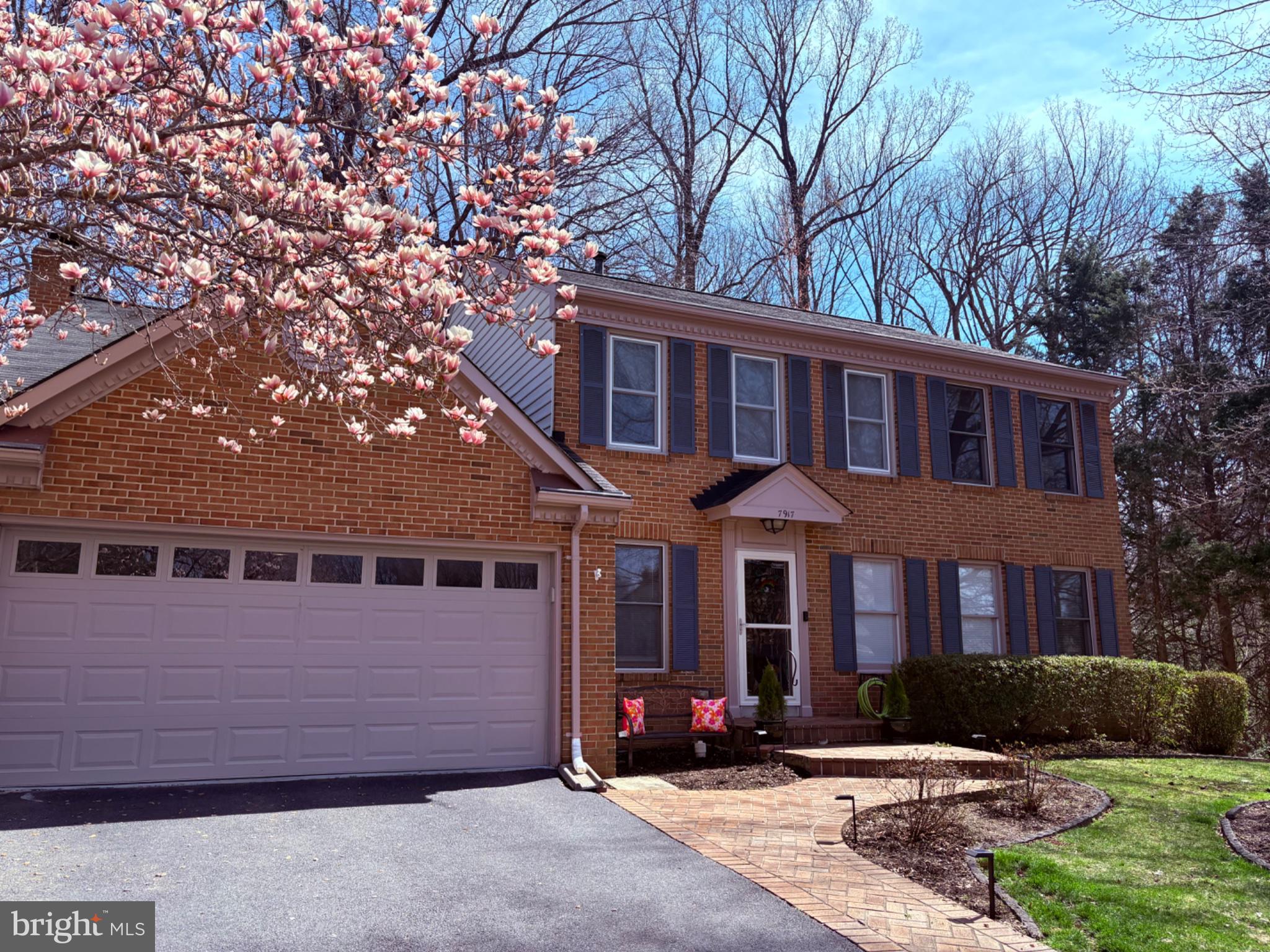 Charming brick home with blooming trees.