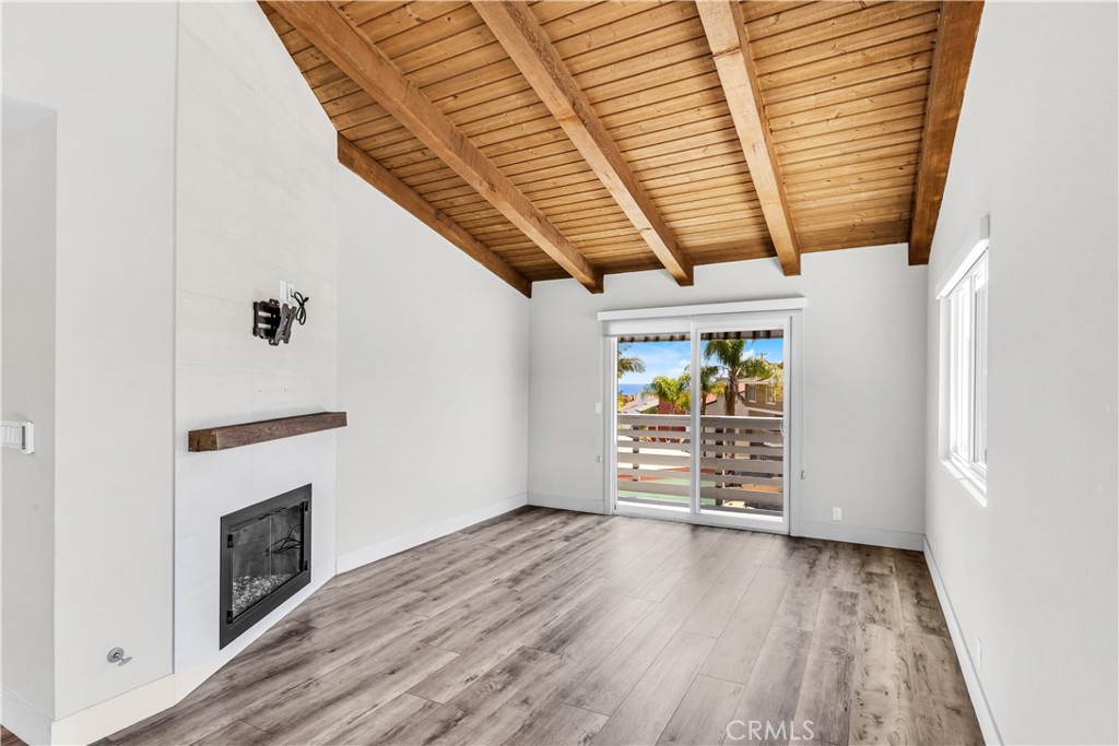 24502 Selva Road, Unit A2 Dana Point, CA 92629 - Photo 6 of 23 an empty room with wooden floor fireplace and windows