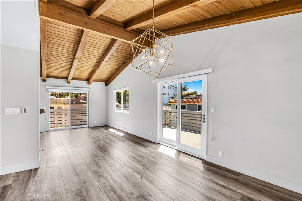 24502 Selva Road, Unit A2 Dana Point, CA 92629 - Photo 7 of 23 an empty room with wooden floor staircase and windows