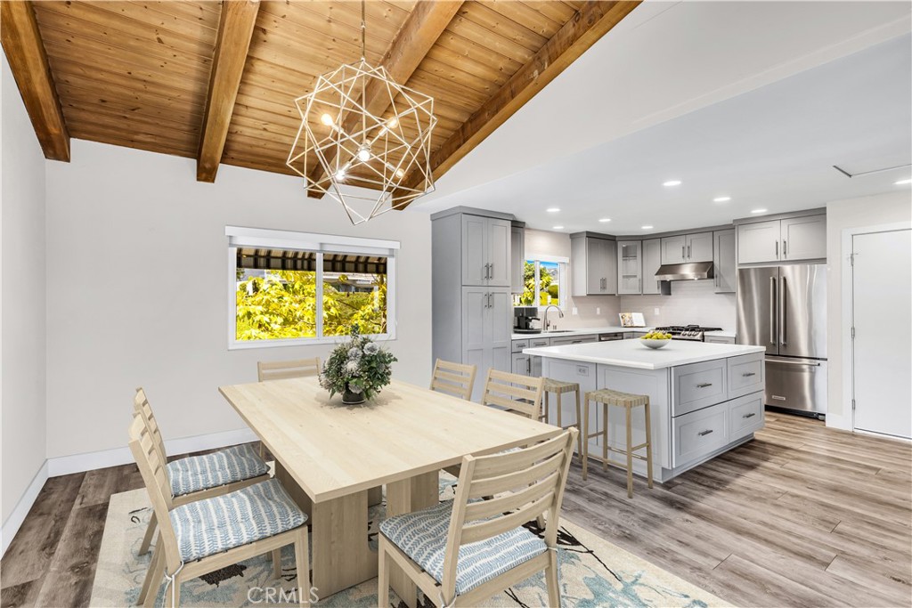 24502 Selva Road, Unit A2 Dana Point, CA 92629 - Photo 8 of 23 a kitchen with stainless steel appliances a stove a sink dishwasher a dining table and chairs with wooden floor