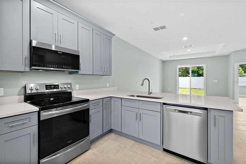 13 Karas Trail Palm Coast, FL 32164 - Photo 11 of 37 a kitchen with cabinets sink and stainless steel appliances