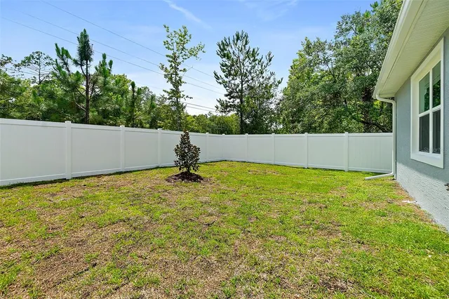 a backyard of a house with table and chairs