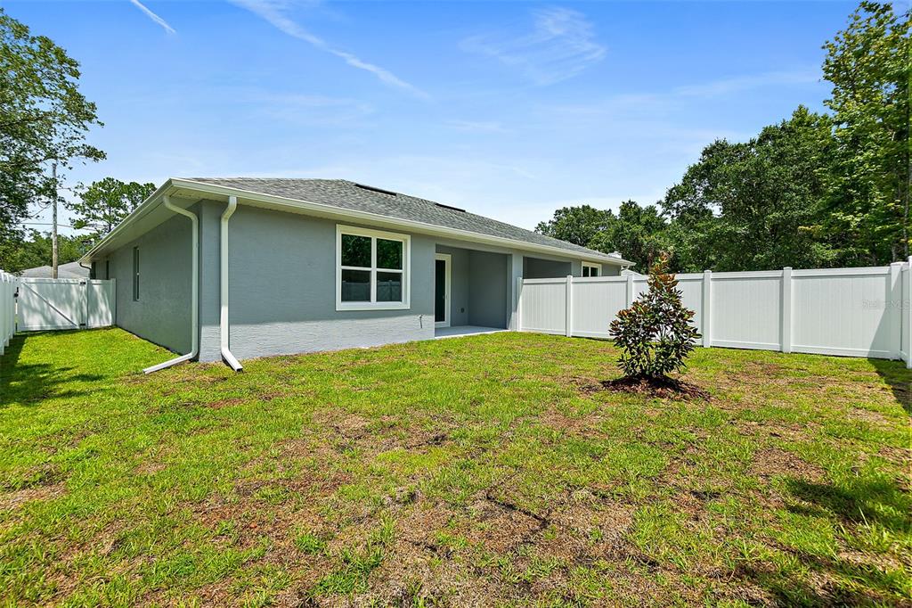 13 Karas Trail Palm Coast, FL 32164 - Photo 36 of 37 a backyard of a house with table and chairs