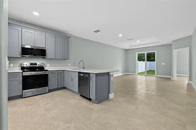 a kitchen with stainless steel appliances granite countertop a refrigerator sink and stove