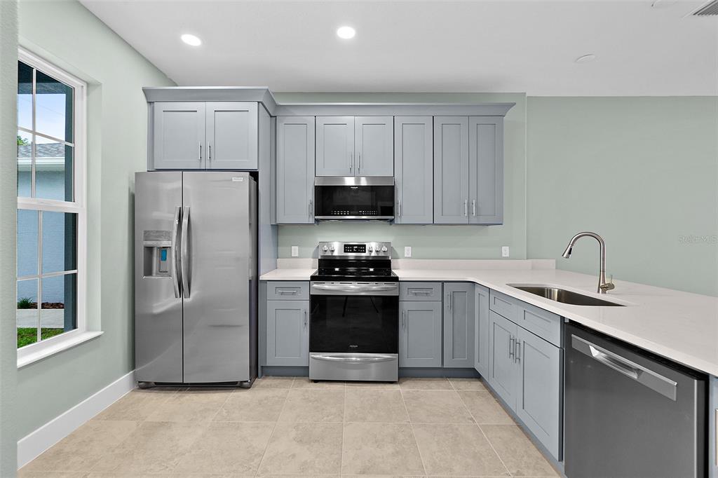 13 Karas Trail Palm Coast, FL 32164 - Photo 8 of 37 a kitchen with stainless steel appliances granite countertop a refrigerator sink and stove
