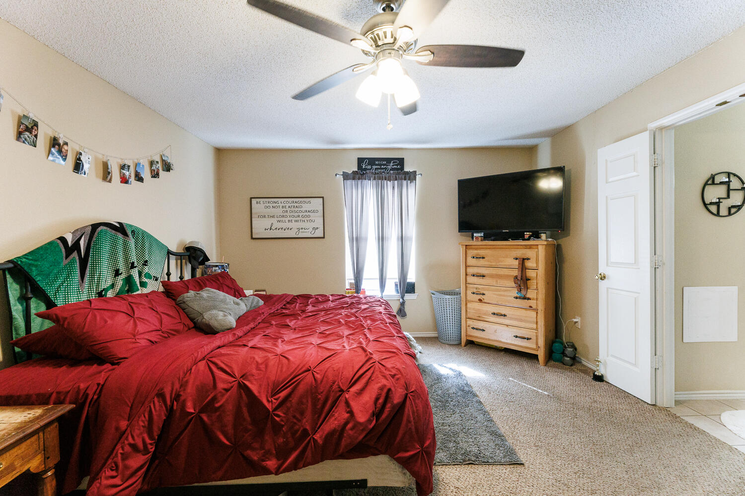 3416 97th Street Lubbock, TX 79423 - Photo 11 of 14 a bedroom with a bed and a flat tv screen on dresser