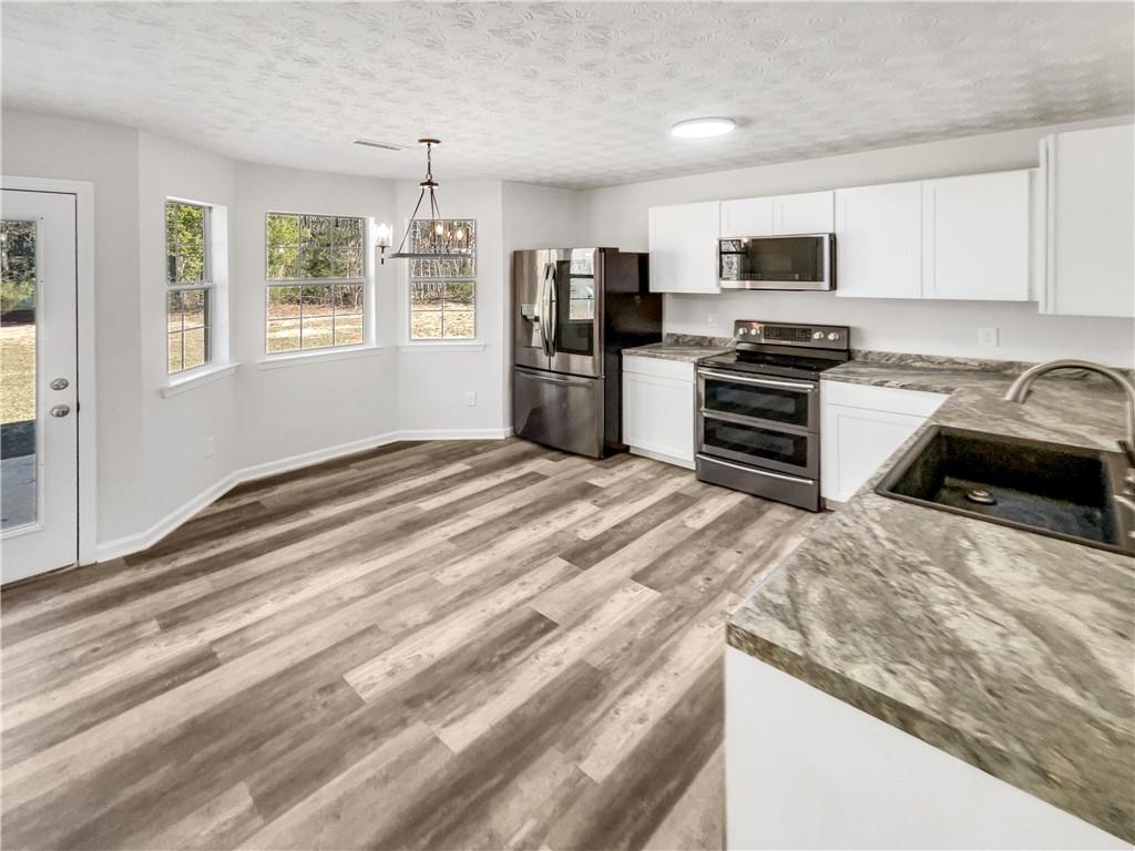 24 Chelsea Lane Grantville, GA 30220 - Photo 8 of 20 a kitchen with granite countertop a refrigerator and a stove top oven