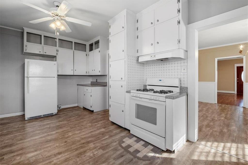 1 Poplar Street Northeast Rome, GA 30161 - Photo 17 of 28 a kitchen with stainless steel appliances white cabinets and wooden floor