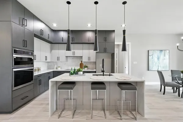 a kitchen with stainless steel appliances kitchen island granite countertop a sink a stove a dining table and chairs