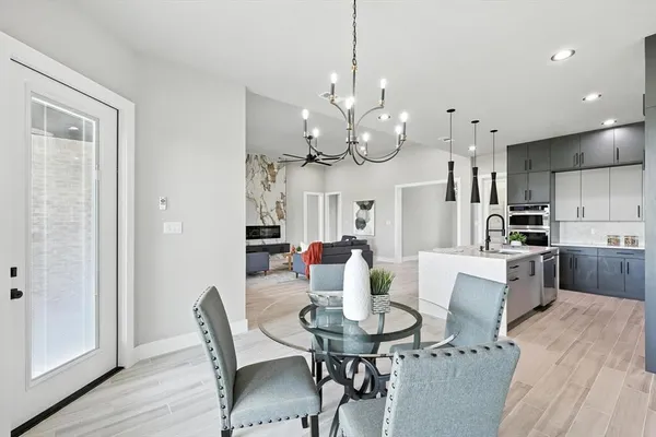 a view of a dining room with furniture a chandelier and wooden floor