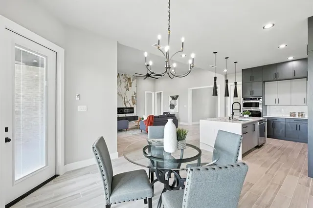 a view of a dining room with furniture a chandelier and wooden floor