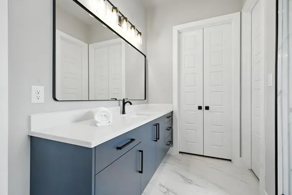 a bathroom with a sink shower and a mirror