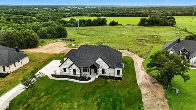 an aerial view of a house with big yard