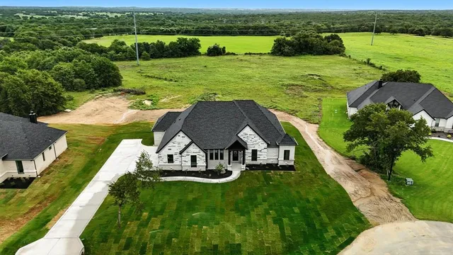 an aerial view of a house with a yard