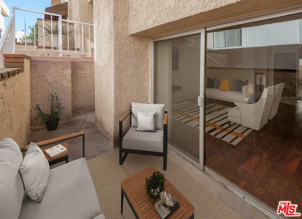 a balcony with furniture and a potted plant