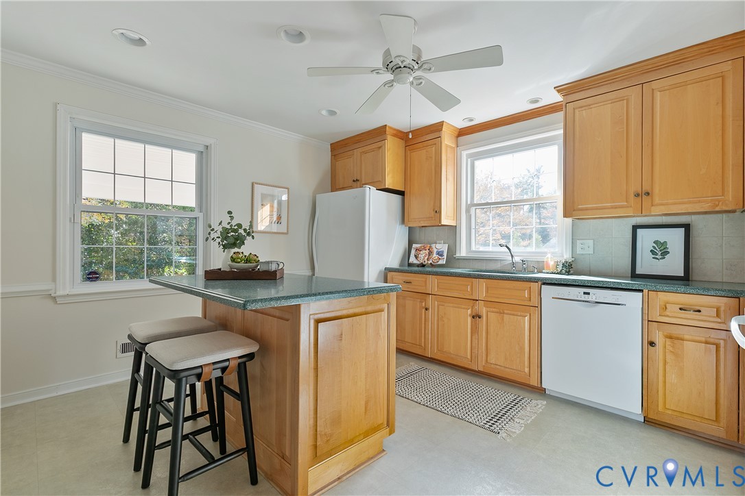 10200 Merrigan Road Richmond, VA 23235 - Photo 18 of 47 a kitchen with stainless steel appliances granite countertop a table chairs sink and cabinets