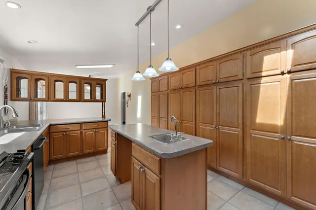 a kitchen with granite countertop a sink and refrigerator