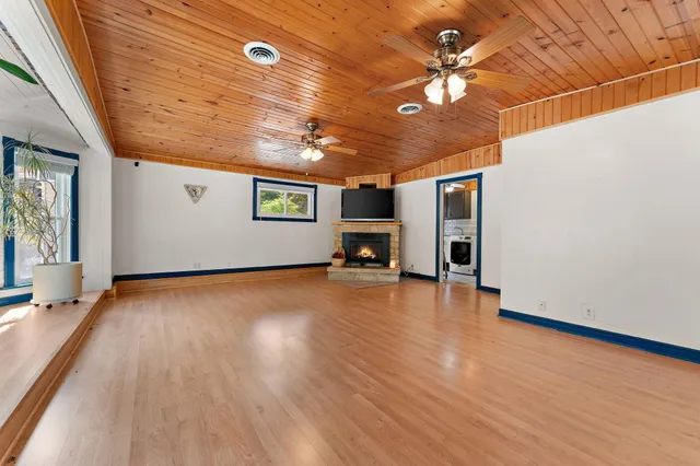 a view of empty room with a window and a ceiling fan
