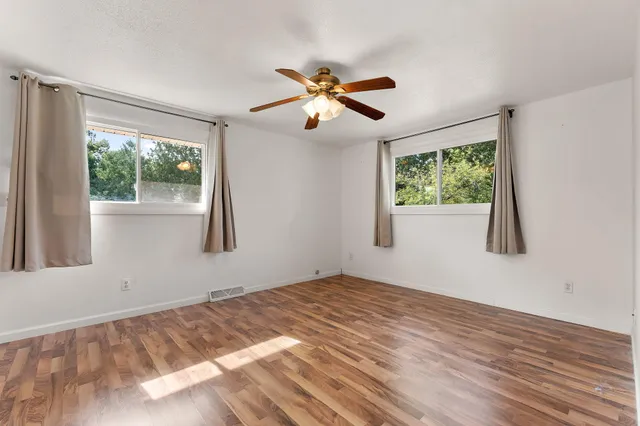 a view of empty room with window and ceiling fan
