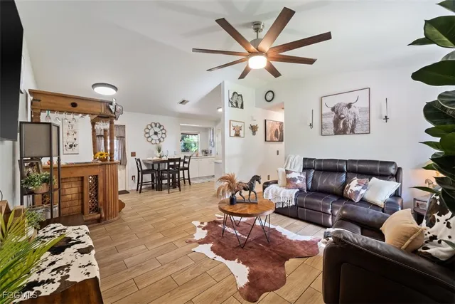 a living room with furniture a chandelier and a rug