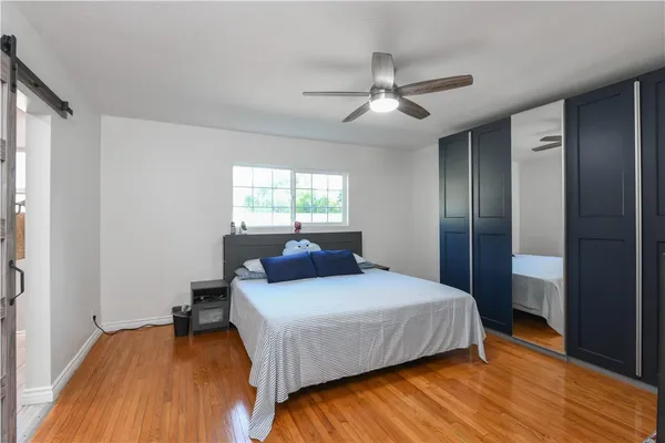 a bedroom with a bed and a wooden floor