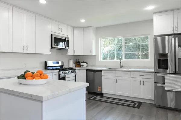 a kitchen with stainless steel appliances a stove a sink and a microwave