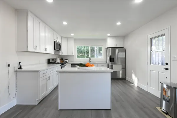 a kitchen with white cabinets and stainless steel appliances