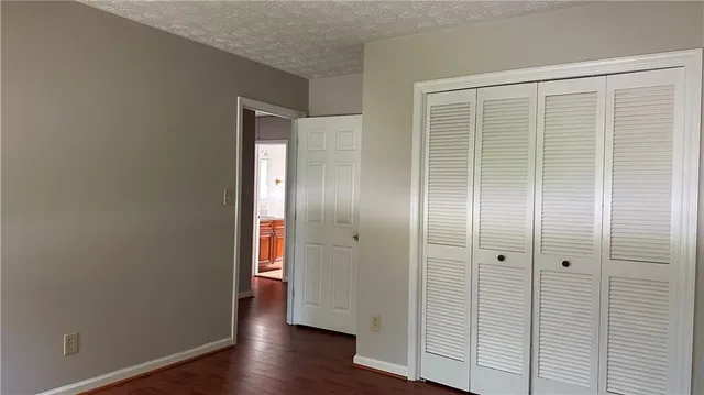 an empty room with wooden floor and mirror