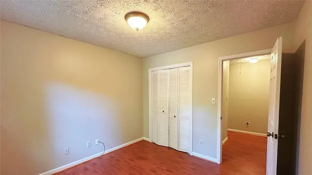 an empty room with wooden floor and entrance