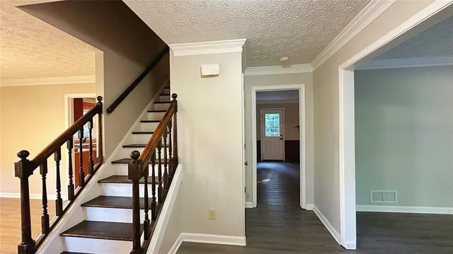 a view of a hallway with wooden floor and stairs