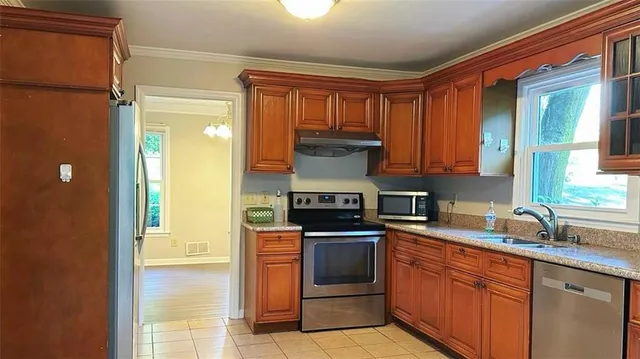 a kitchen with stainless steel appliances granite countertop a stove a sink and a refrigerator