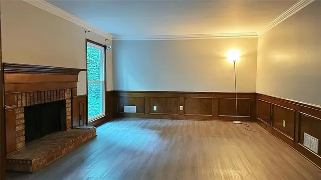 a view of a livingroom with wooden floor and a fireplace