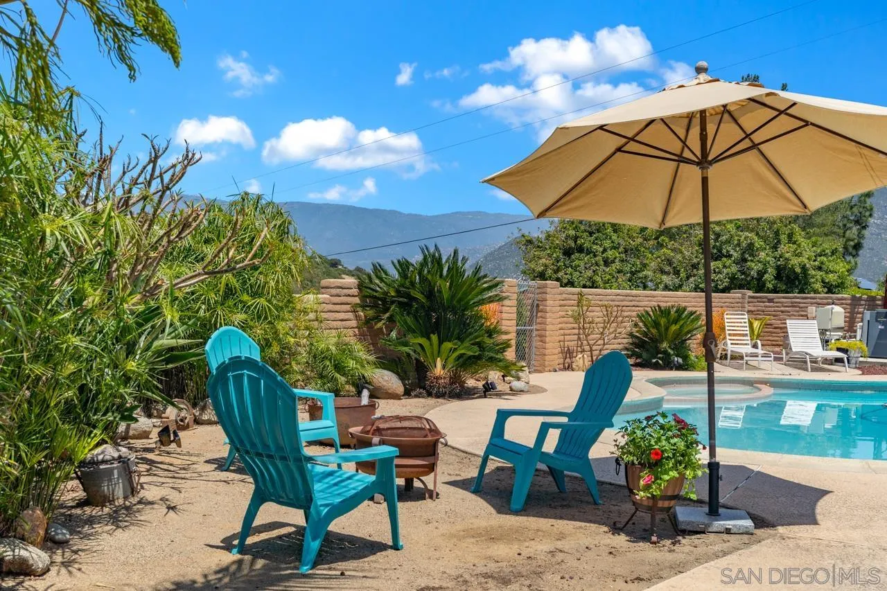 a view of a chairs and table in the backyard