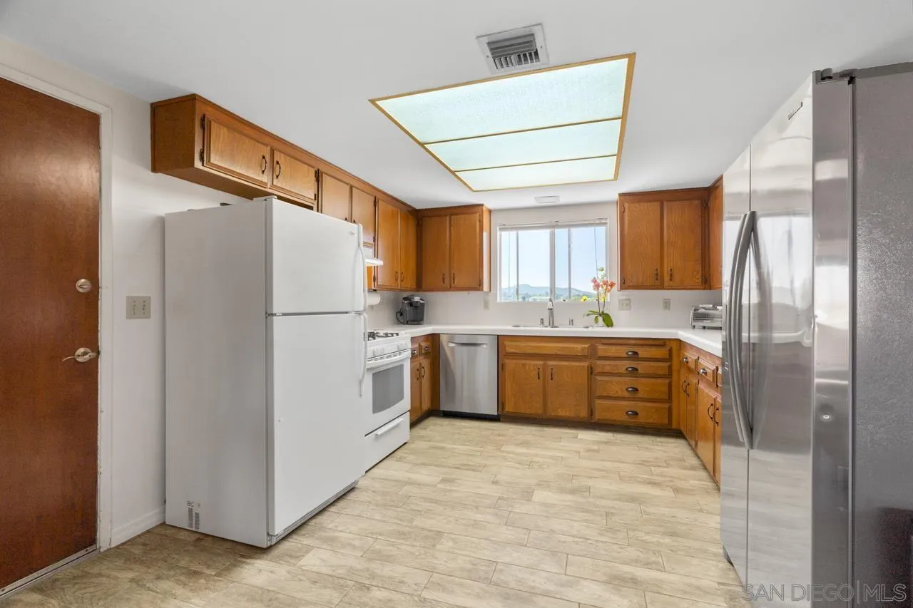 31478 Valley Center Road Valley Center, CA 92082 - Photo 26 of 66 a kitchen with a refrigerator a sink and cabinets