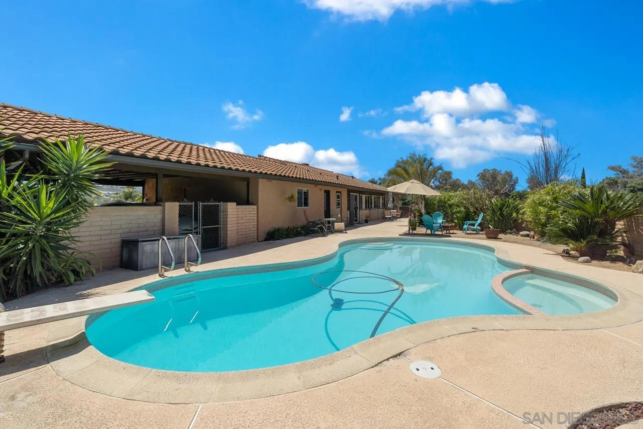 31478 Valley Center Road Valley Center, CA 92082 - Photo 4 of 66 a view of a swimming pool with an outdoor seating and house in the background