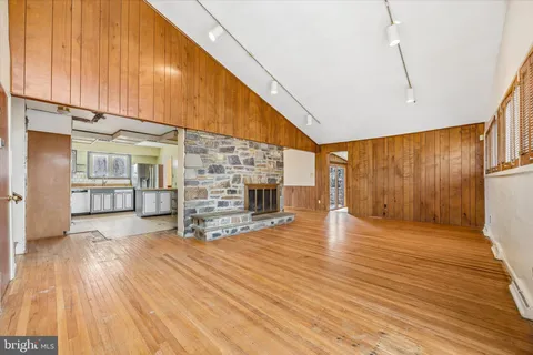 a view of empty room with wooden floor and fireplace
