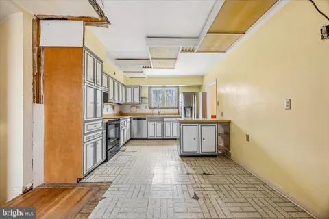 a kitchen with stainless steel appliances granite countertop a refrigerator and a stove