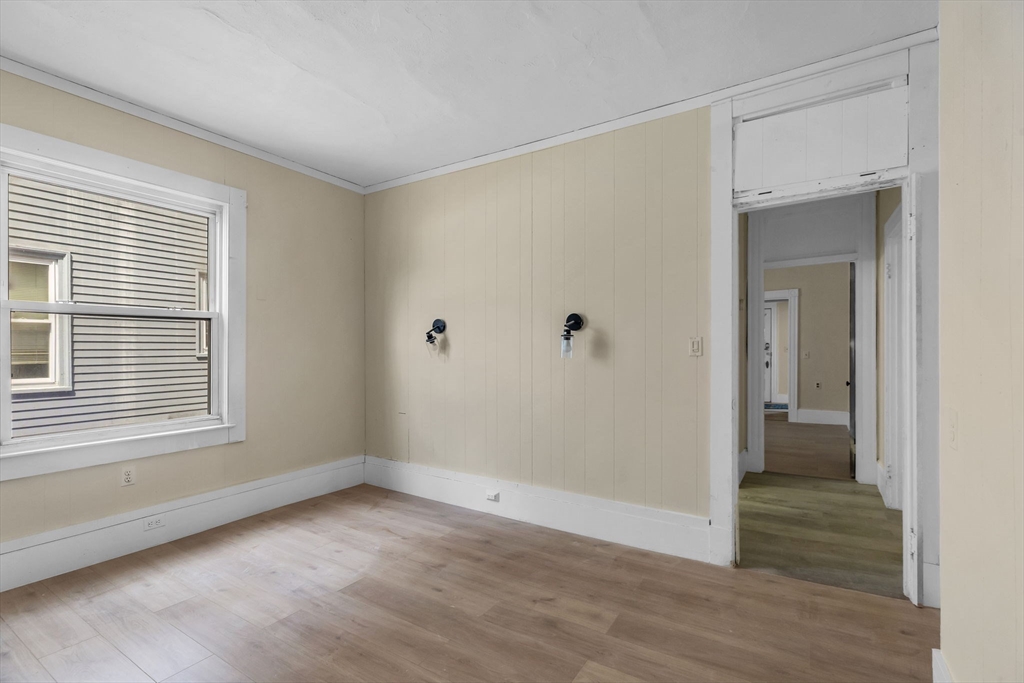 102 Florida Street Springfield, MA 01109 - Photo 14 of 45 a view of an empty room with wooden floor and a window