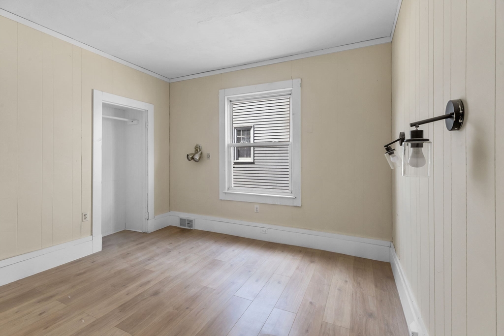 102 Florida Street Springfield, MA 01109 - Photo 15 of 45 an empty room with wooden floor and windows