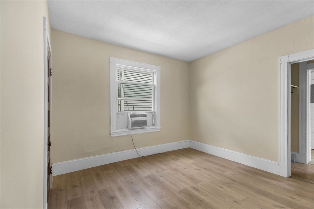 102 Florida Street Springfield, MA 01109 - Photo 16 of 45 an empty room with wooden floor and windows